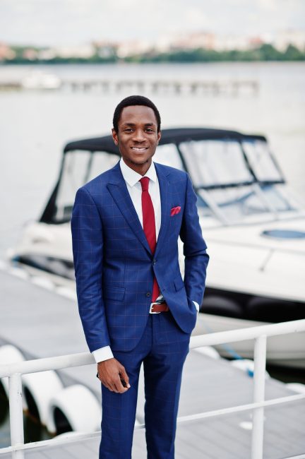African american happy successful man at suit against yacht. Rich black business man.